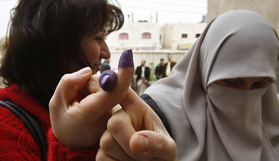 Muslim and Christian Iraqi women living in Jordan hold up their ink-stained index fingers after casting their ballots in Amman, March 5, 2010. 