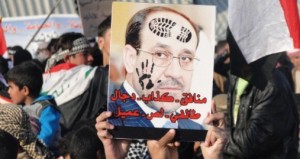 Iraqi Sunni protestors hold up a portrait of Prime Minister Nuri al-Maliki with slogans reading in Arabic, "liar...sectarian, thief, collaborator" during a protest against him on the main highway to Syria and Jordan near Ramadi, Anbar's provincial capital west of Baghdad, on January 4, 2012. . AFP PHOTO / AZHER SHALLAL        (Photo credit should read AZHER SHALLAL/AFP/Getty Images)