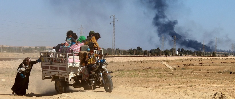 TOPSHOT - An Iraqi woman pushes a tricycle as government forces evacuate hundreds of Iraqis from the town of Heet in Iraq's Anbar province, to a safe area far from the battlefields where Iraqi troops are trying to retake the western town from the Islamic State (IS) group on April 4, 2016. Earlier in the week Iraqi security forces recaptured parts of Heet, which was one of the largest population centres in Anbar province still held by the Islamic State (IS) group, but other areas remain under jihadist control. / AFP / MOADH AL-DULAIMI (Photo credit should read MOADH AL-DULAIMI/AFP/Getty Images)