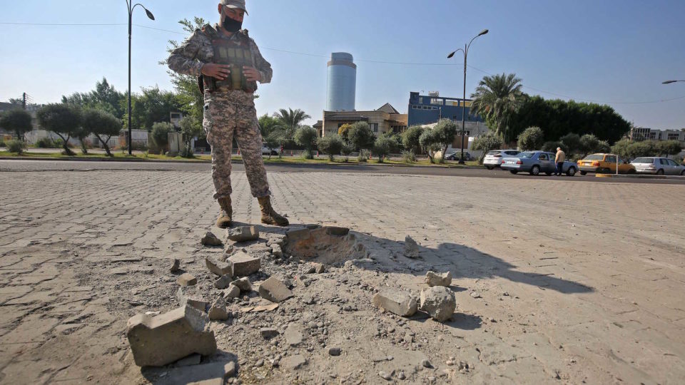 A member of the Iraqi security forces inspects the damage outside Zawraa park in Baghdad, after a volley of rockets slammed into the Iraqi capital breaking a monthlong truce on attacks against the US Embassy, Iraq, Nov. 18, 2020.